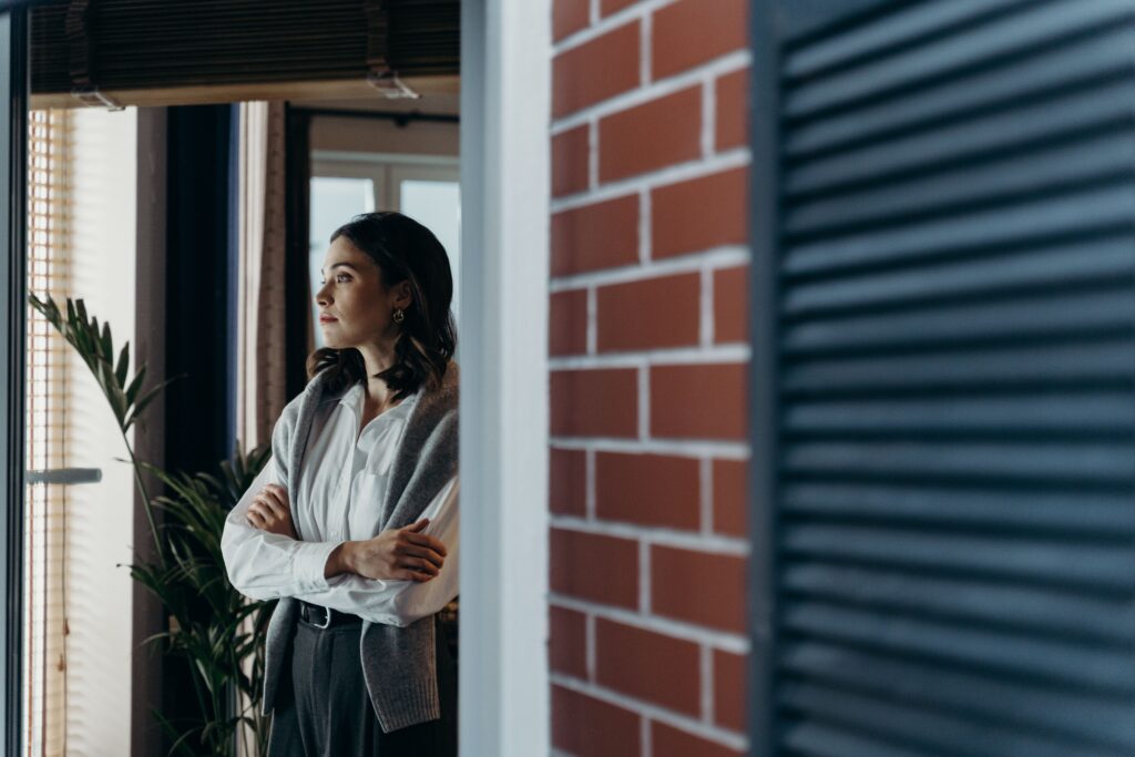 Businesswoman stares into distance in office considering how lombard lending could be used for her business liquidity needs