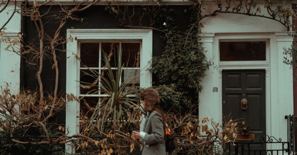 Image for Lombard lending for estate planning blog showing woman dressed in autumn clothes walking in front of a London terraced house.